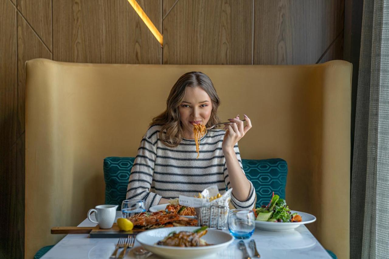 Pullman Sharjah Hotel Екстериор снимка A woman eating at a restaurant